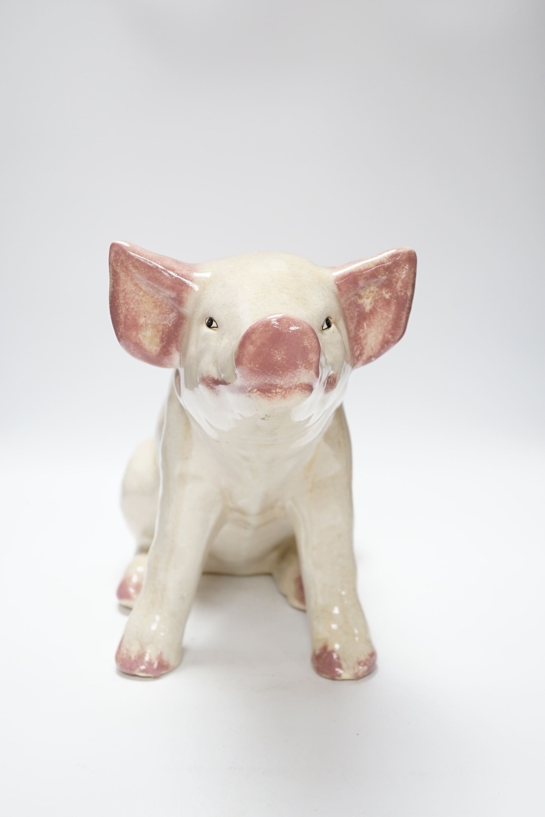 A large earthenware model of a seated piglet, 31cm high